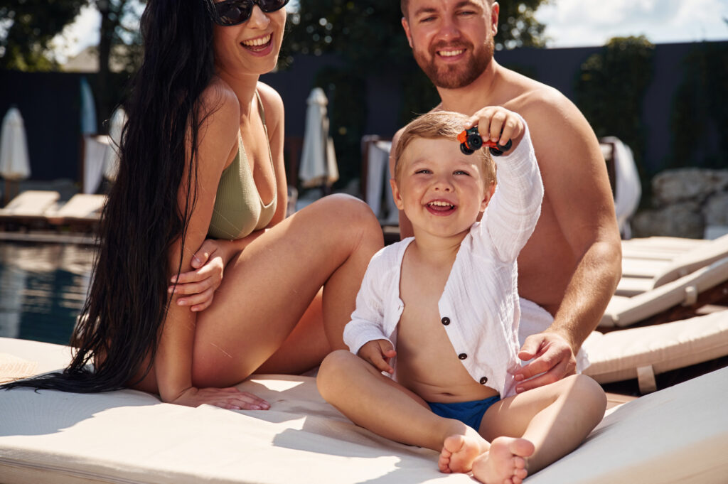 Familie som leker i solen. Det er lurt å sjekke en app for å finne ut om det farlig UV-stråling når man skal sole seg.